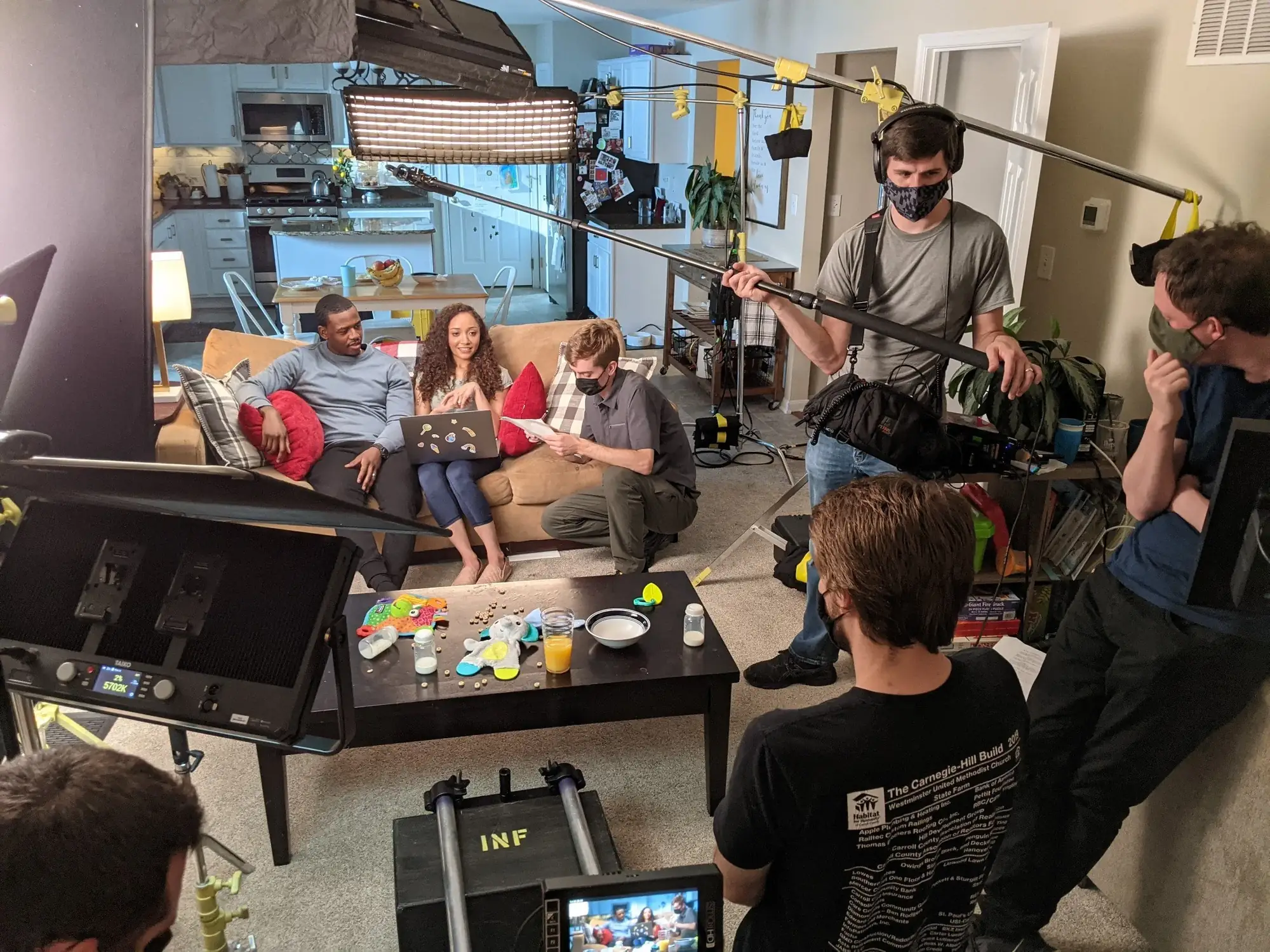 Film crew shooting a family scene on a living room set