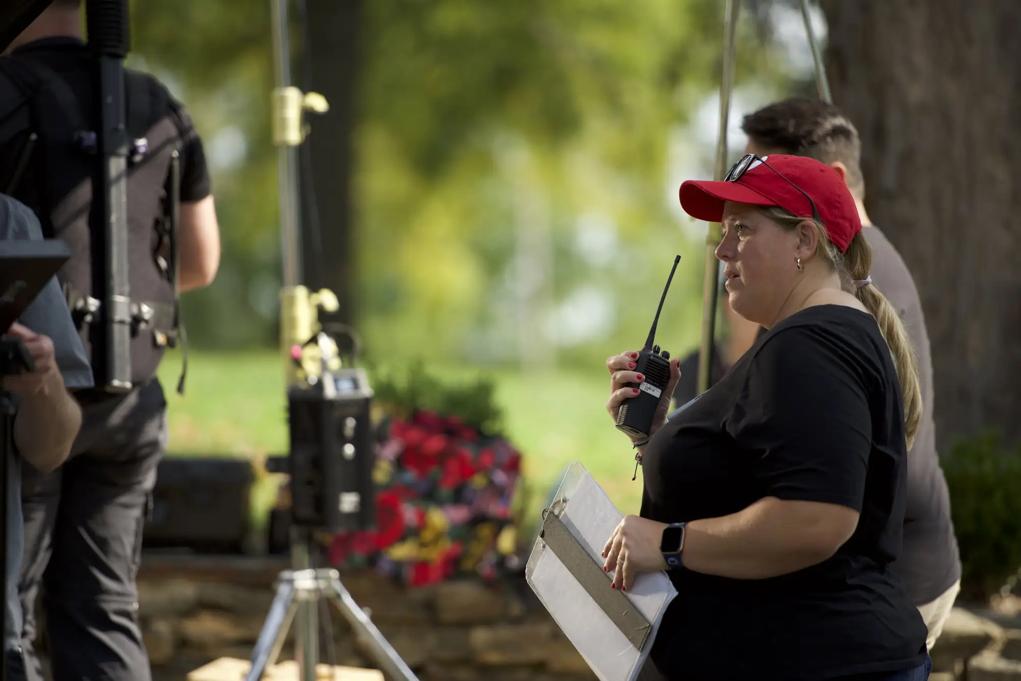 Assistant director with radio and clipboard on an outdoor set