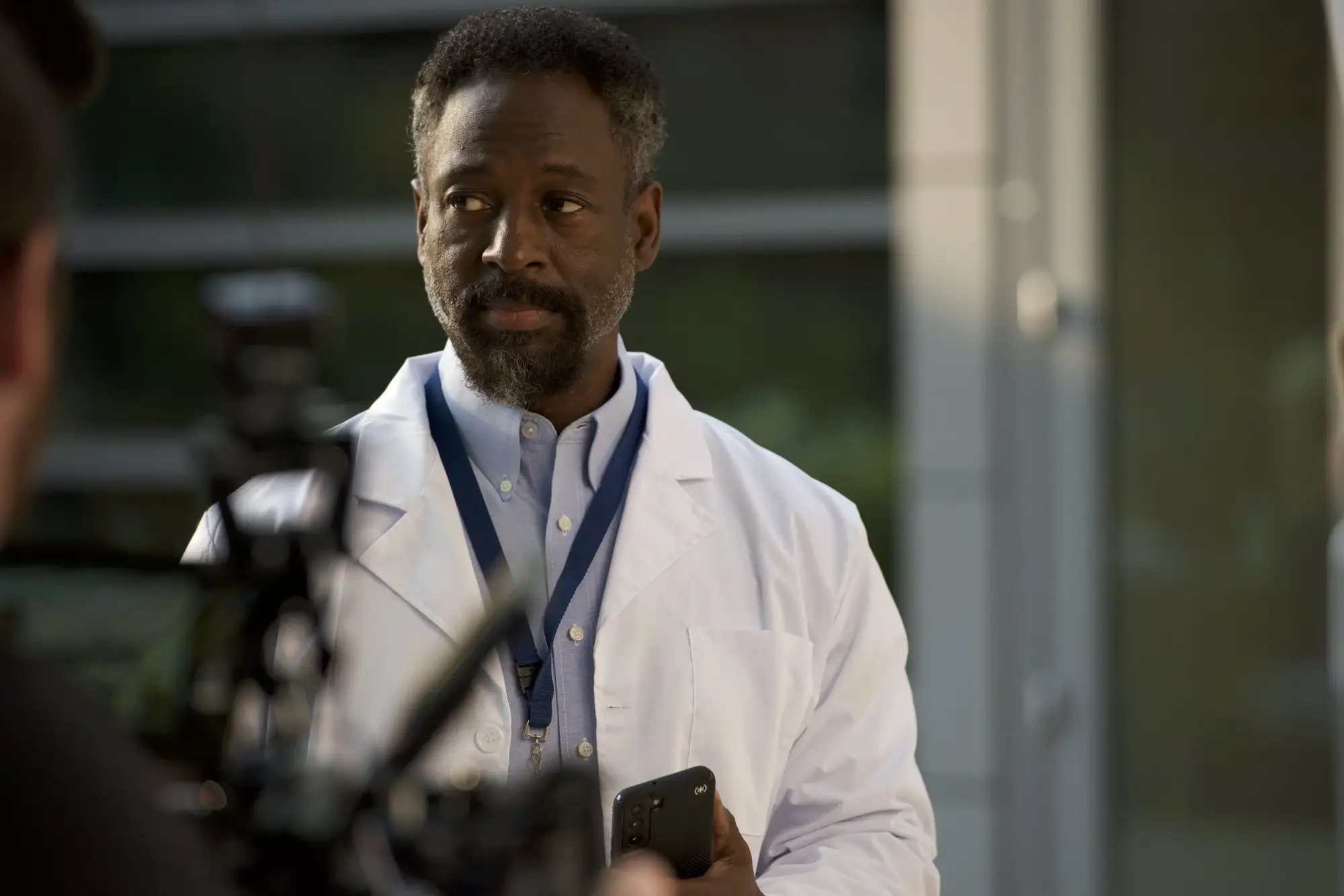 Actor in a white coat on set between takes