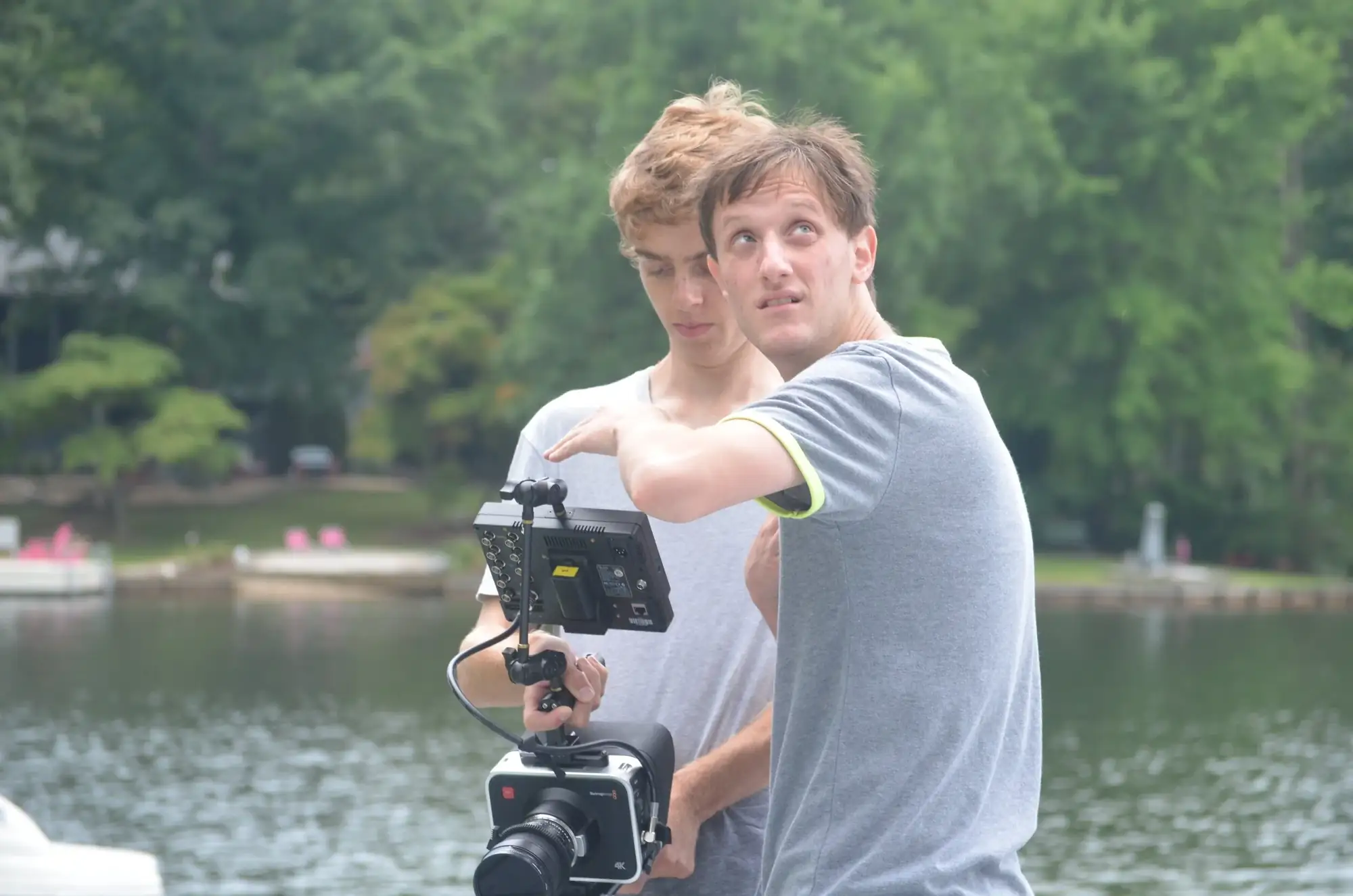Two filmmakers checking a shot beside a lake