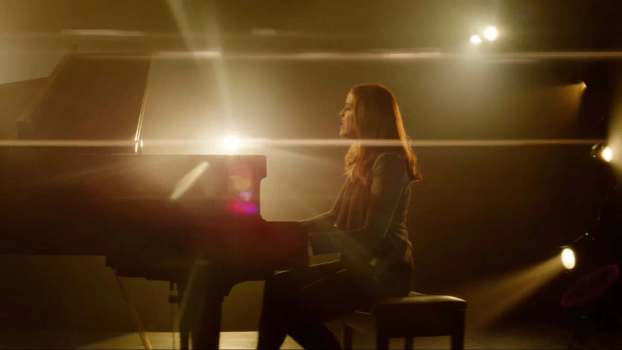 Ghost Light music video — singer at a grand piano in warm haze